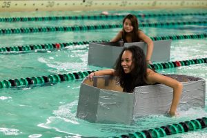 Cardboard boats racing in swimming pool