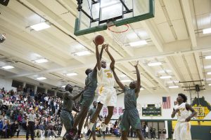 Basketball players reaching for the ball.