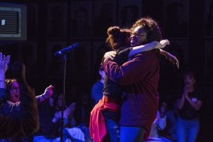 Students hugging in spotlight