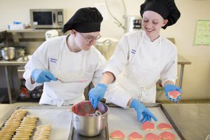 Two students decorating cookies