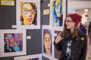 Student poses next to her art project.