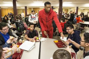 Basketball player handing out tickets to students