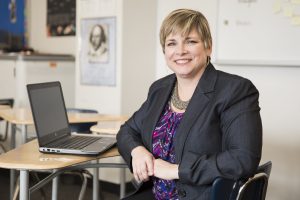 Teacher sitting at a desk with a computer