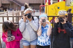 Four students holding cameras