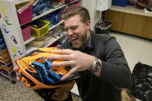 Man helps child put on bike helmet.