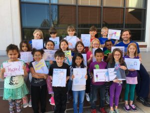 Downtown School students pose as a class with their books.